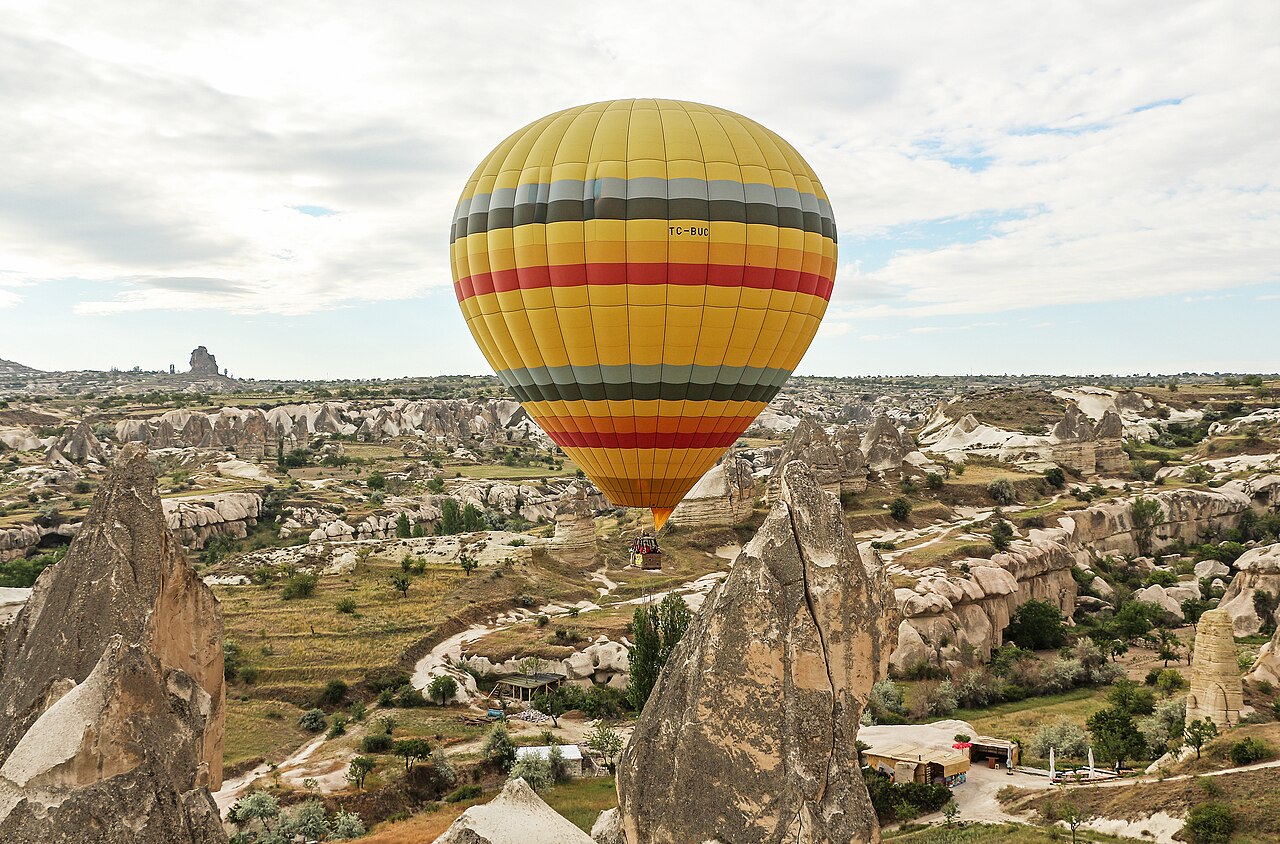 A hot air balloon flying above the rock formations of Cappadocia