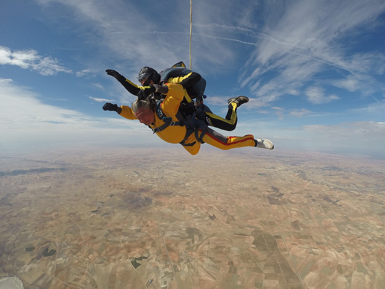 A tandem skydiving guest and instructor in freefall